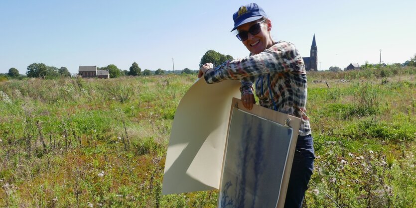 Silke Schatz steht auf einer Wiese, dort gab es früher das Dorf Manheim - die Reste des Dorfs verschwinden auch noch - wegen Braunkohleabbau