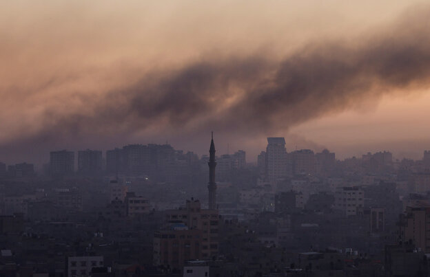 Panorama von Gaza-Stadt, im Vordergrund ein Minarett, Rauch steigt auf