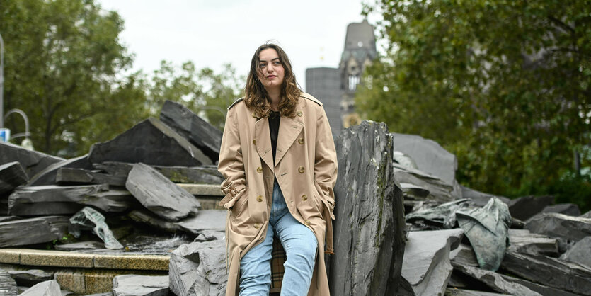 Dana Vowinckel steht in Berlin am Olof-Palme-Platz vor den zerbrochenen Steinen des Ammonitenbrunnen