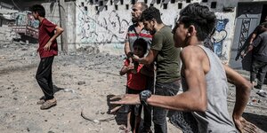 Strassenszen in Gaza: Ein Mann rennt, zwei Männer trösten einen Jungen, der weint