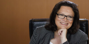 Andrea Nahles lächelt, das Kinn auf die Faust gestützt