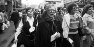 Schwarzweiß-Fotografie ais dem 70 Jahren: Mehrere Frauen laufen skandierend auf der Straße