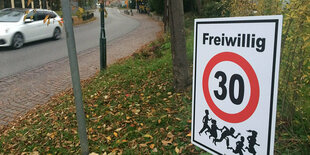 Ein «Freiwillig-Tempo-30»-Schild steht an einer Straße.