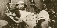 Toulouse Lautrec liegt eingeschlafen in einem Liegestuhl, neben sich eine Birne