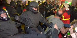 Polizisten treten einen Demonstranten