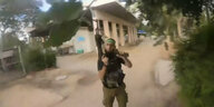Ein Videobild zeigt einen bewaffneten Hamaskämpfer mit erobenem Maschinengewehr in einer Siedlung