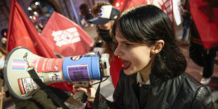 Demonstration mit Megafon und Fahnen.