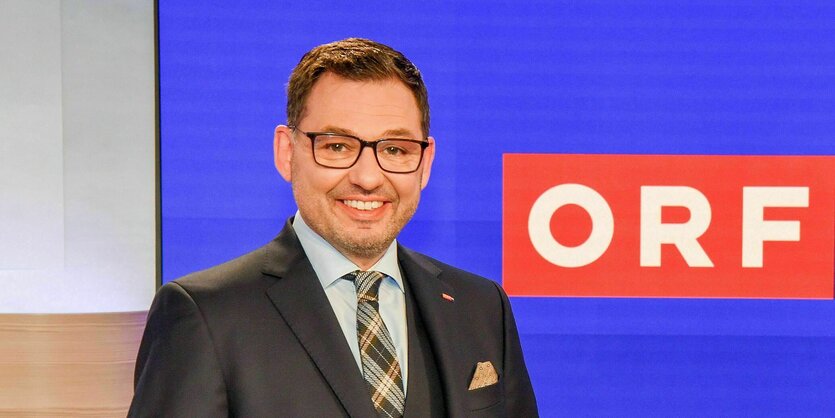 Der lächelnde Robert Ziegler steht an einem Pult, hinter ihm das Logo des ORF