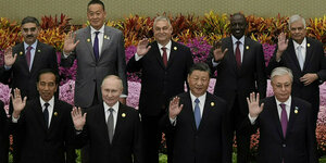 In Peking präsentieren sich Staats- und Regierungschefs auf einem offiziellen Foto mit erhobener rechter Hand: In der Mitte sind Wladimir Putin, Xi Jinping und in der Reiehe dahiner Wirktor Orban.