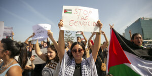 Propalästinänsische Demonstrierende mit Schildern und Flaggen