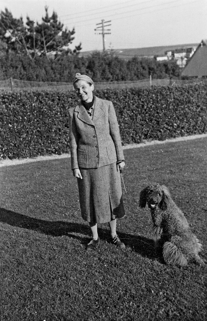 Grete Ring in einem Garten, neben ihr ein Pudel