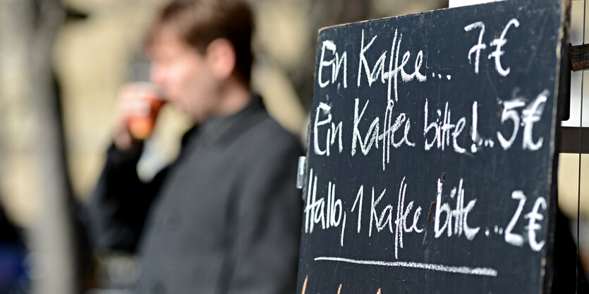 Preistafel mit Höflichkeitsformeln vor einem Café