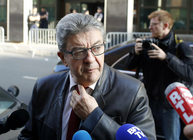 Jean-Luc Melenchon, Parteichef der französischen Linkspartei La France Insoumise ist von Mikrofonen umzingelt. Im Hintergrund ein schwarzes Auto und ein Fotograf.