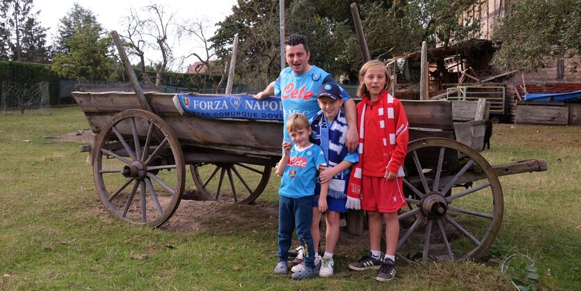 Antonino Verde im Neapel-Dress mit Kindern vor einem alten Holzkarren