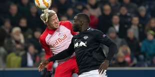 Ein Kobfballduell zweier Spieler, einer von RB Leipzig, der andere von RB Salzburg