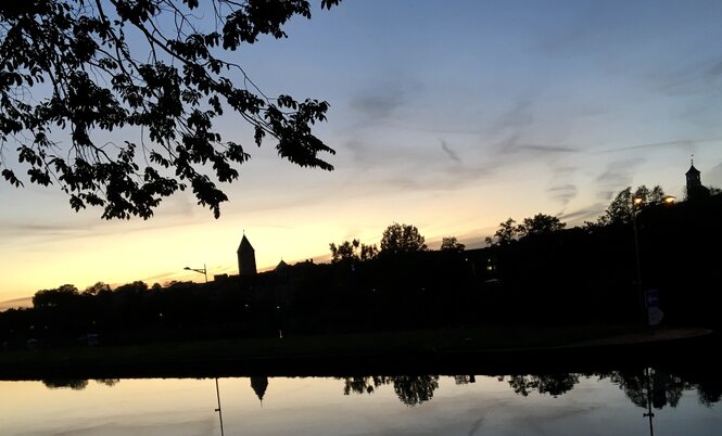 Abendliche Silhouette von Schweinfurt, sich im Fluss spiegelnd