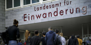 Wartende Menschen stehen vor dem Landesamt fuer Einwanderung in Berlin