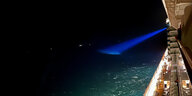 Suchscheinwerfer leuchtet im Dunkeln auf Meeresoberfläche