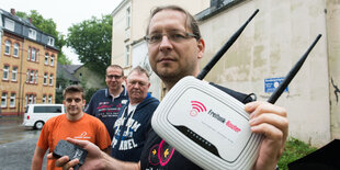 Mitarbeiter der Freifunk-Initiative halten einen Router hoch