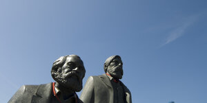 Figuren von Marx und Engels vor blauem Himmel, es sind nurdie Köpfe zu sehen