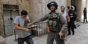 Ein Palästinenser und ein israelischer Soldat