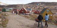 Inuitfamilie eilt mit Kinderwagen zu einer Hochzeit in der Kirche des ostgrönländischen Scoresbysund