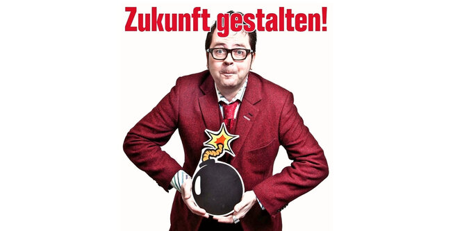 Das Foto zeigt den Satiriker Oliver Maria Schmitt mit einer Bombenattrappe