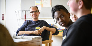 Lehrer, Schülerinnen und Schüler in einem Klassenraum in Bremen.