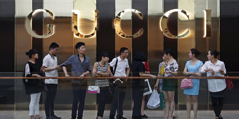 Touristen vor dem Logo eines Gucci-Shops