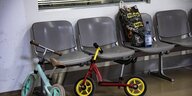 Kinderfahrräder, Plastiktüte und Wasserflasche im Wartebereich eines Ankunftszentrums für Geflüchtete