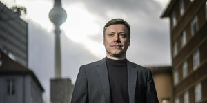 Martin Schirdewan steht im Freien, im Hintergrund ist der Berliner Fernsehturm zu sehen