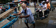 Marktszene in Colombo, im Vordergrund zählt eine Verkäuferin Geldscheine
