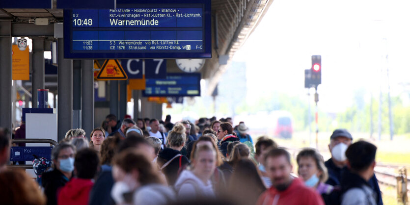 Fahrgäste warten auf einem Bahnsteig auf einen Zug