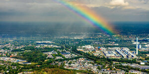 Ein Regenbogen im Himmel über einer Landschaft mit Fabriken