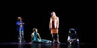 Vier Frauen stehen vor einem schwarzen Hintergrund auf einer Theaterbühne