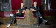 Markus Kavka und Elmar Giglinger sitzen auf Bänken im Festsaal Kreuzberg