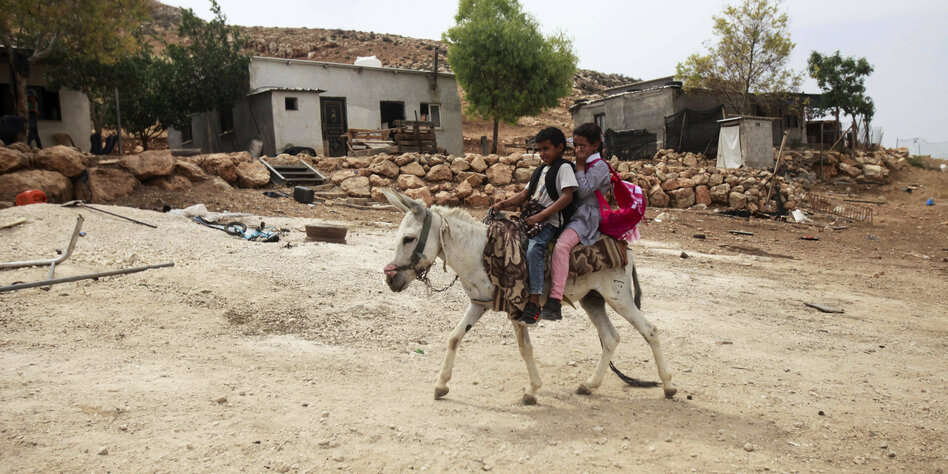 Zwei beduinische Mädchen auf einem Esel