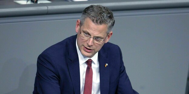 Christoph de Vries pricht im blauen Jacket und roter Krawatte im Bundestag
