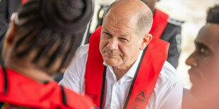 Olaf Scholz mit einer roten Rettungsweste