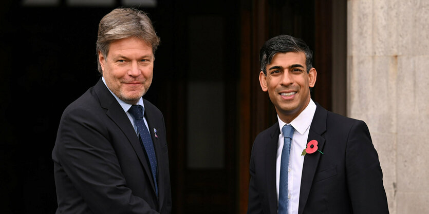 Robert Habeck und Rishi Sunak schütteln Hände vor einem Haus