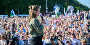 Luisa Neubauer steht auf der Bühne vor Tausenden von Demonstrant*innen