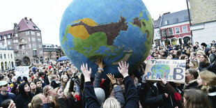 Fridays-for-Future-Aktivisten halten einen Erdball in der Luft