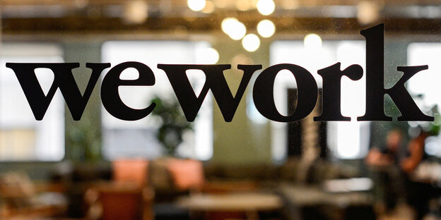 Das Logo "WeWork" an einer Glasscheibe