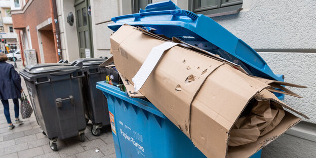 Ein überfüllter Müllcontainer für Papier und Pappe