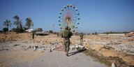 Israelische Soldaten in einer mit Trümmern übersäten Landschaft, im Hintergrund ein Riesenrad