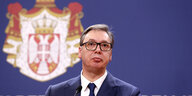 Serbiens Präsident Aleksandar Vučić vor dem Nationalwappen Serbiens
