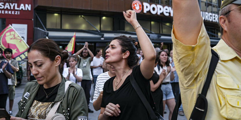 Menschen mit erhobenen Armen und Fahnen