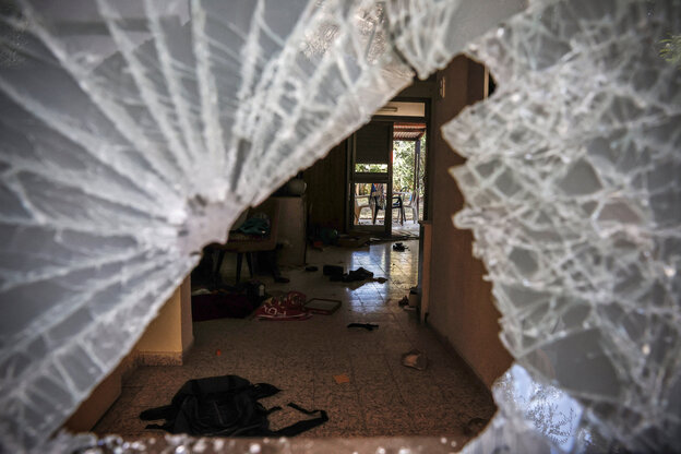 Ein Blick durch eine zerschossene Glasscheibe in ein Haus im Kibbutz Nir Oz