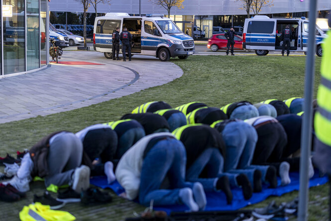 Betende Männer auf einer Straße.