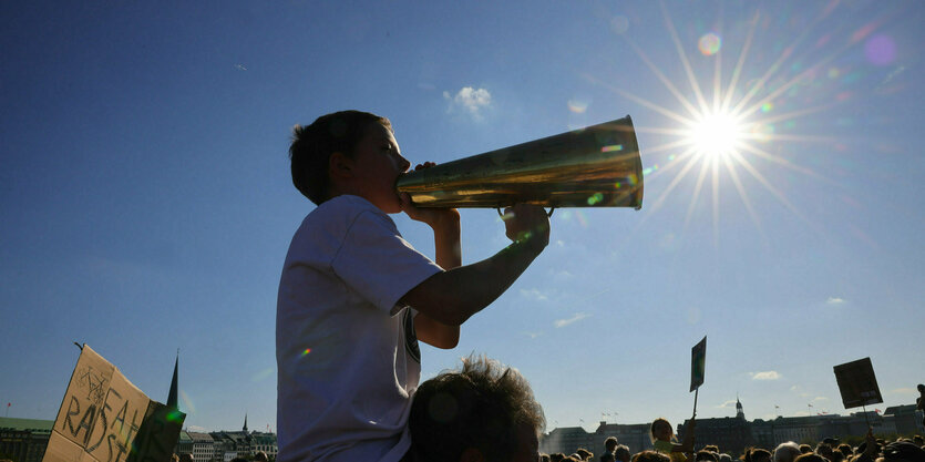 Ein Junge mit einem Megafon auf einer Fridays of Future Demo in Hamburg